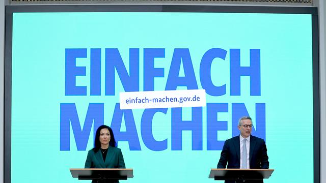 Eine Frau und ein Mann stehen an Redner-Pulten. Hinter Ihnen ist groß geschrieben: Einfach Machen. Und etwas kleiner: einfach-machen.gov.de