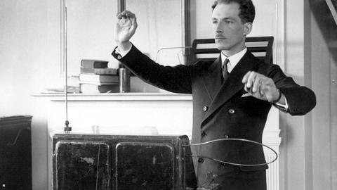 Auf einem Foto vom 12.04.1928 steht Prof. Leon Theremin vor seinem Instrument und spielt. Dabei ähnelt seine Haltung die eines Dirigenten. 