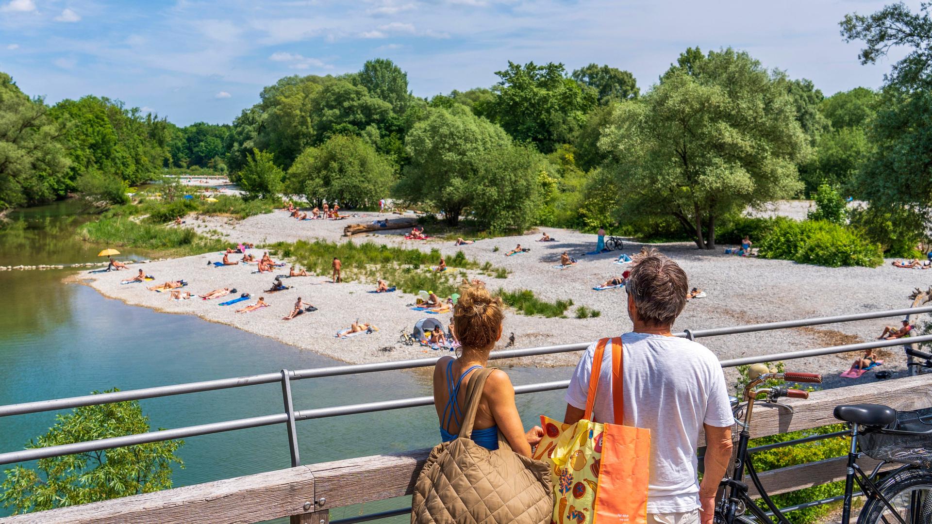 Zwei Urlauber, die auf den Flaucher in München blicken. 