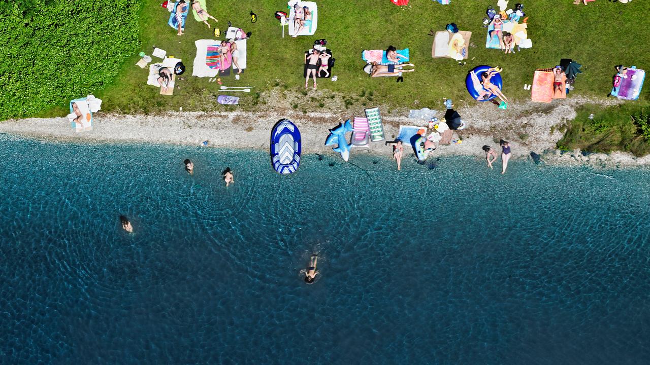 Ein Strandbereich am Starnberger See mit Badegästen im Wasser und an Land. Die Aufnahme ist aus der Luft gemacht.