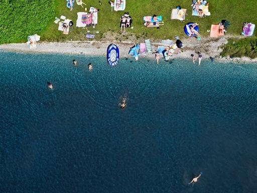 Ein Strandbereich am Starnberger See mit Badegästen im Wasser und an Land. Die Aufnahme ist aus der Luft gemacht.