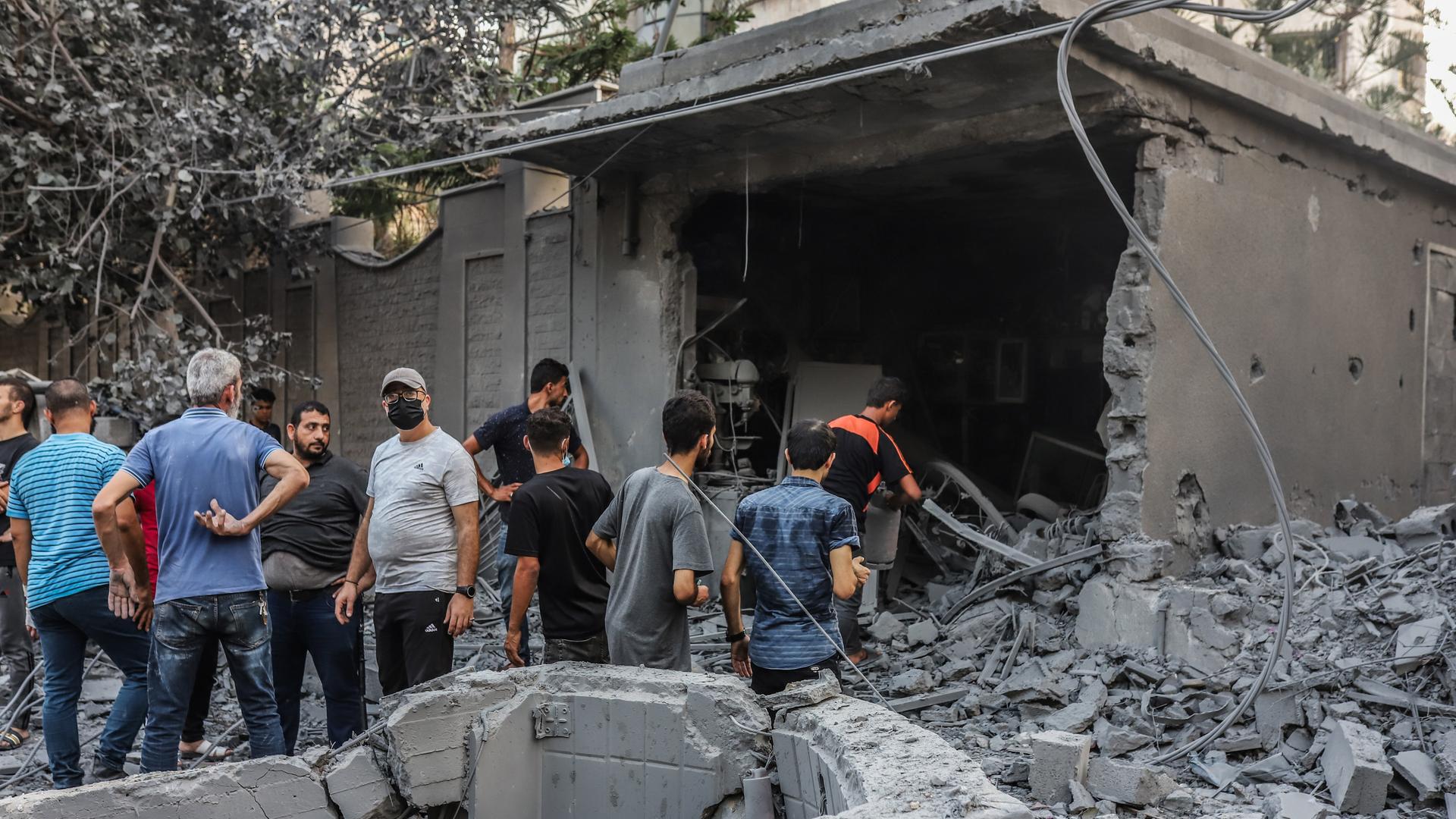 Menschen vor zerstörten Gebäuden in Gaza-Stadt