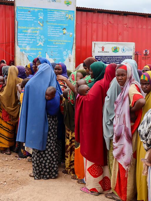 Frauen warten auf die Ausgabe von Nahrungsmitteln an einem Gebäude des Welternährungsprogramms im somalischen Baidoa. 