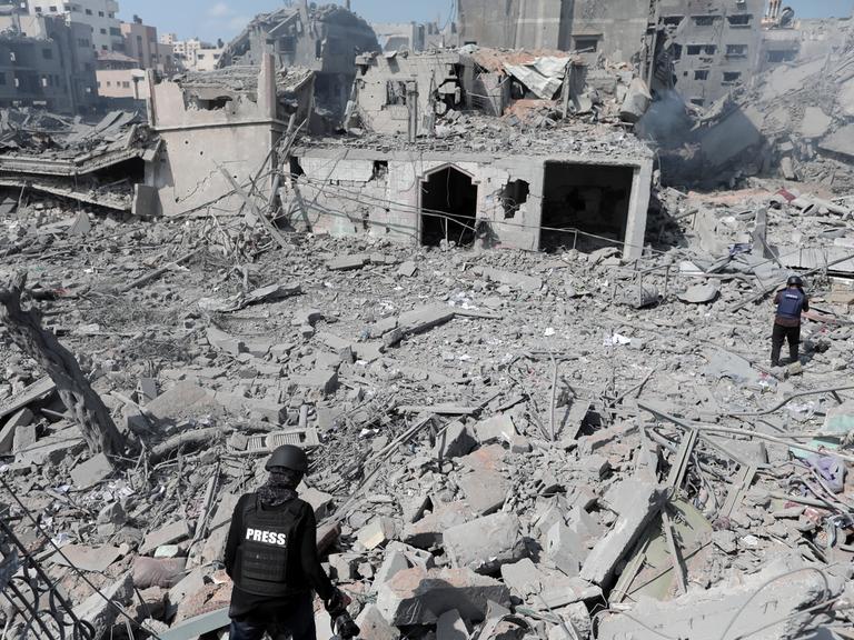 Zwei Personen mit der Aufschrifft PRESS inmitten eines komplett zerstörten Gebäudes  nach einem israelischen Luftangriff in Gaza am 15. Oktober 2023. 