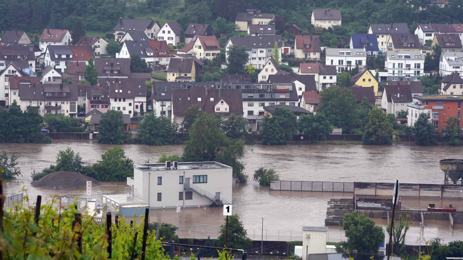 In Benningen am Neckar im Landkreis Ludwigsburg stehen Gebäude im Hochwasser des Neckars, der hier über die Ufer getreten ist.