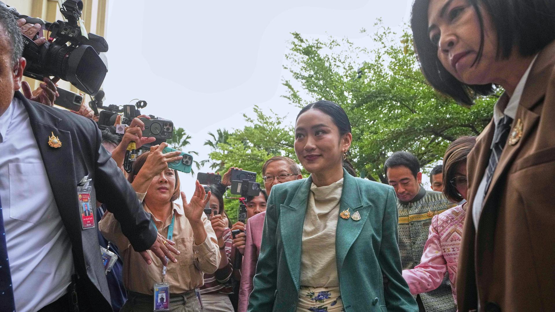 Thailands Ministerpräsidentin Paetongtarn Shinawatra geht in ein Gerichtsgebäude. Mehrere Menschen stehen um sie herum. Thailands Ministerpräsidentin Paetongtarn Shinawatra geht in ein Gerichtsgebäude. Mehrere Menschen stehen um sie herum.