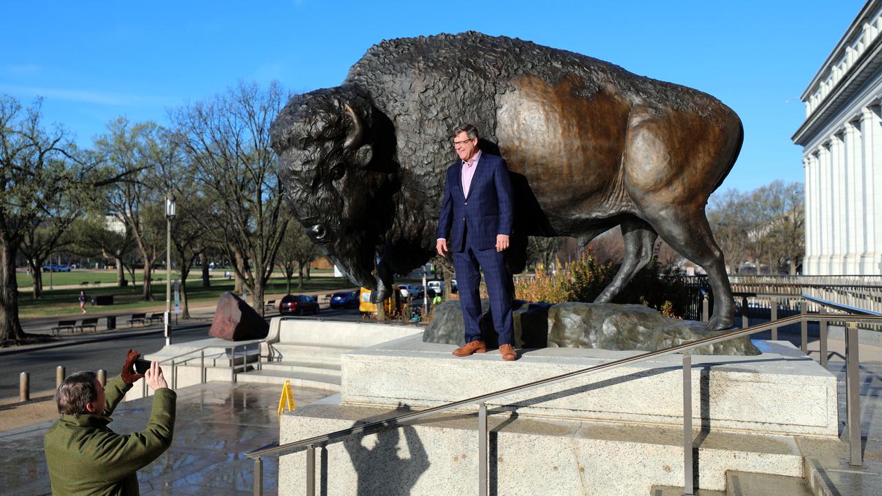 Der Direktor des Smithsonian National Museum of Natural History, Kirk Johnson, lässt sich vor einer der drei bronzenen Bison-Skulpturen fotografieren.