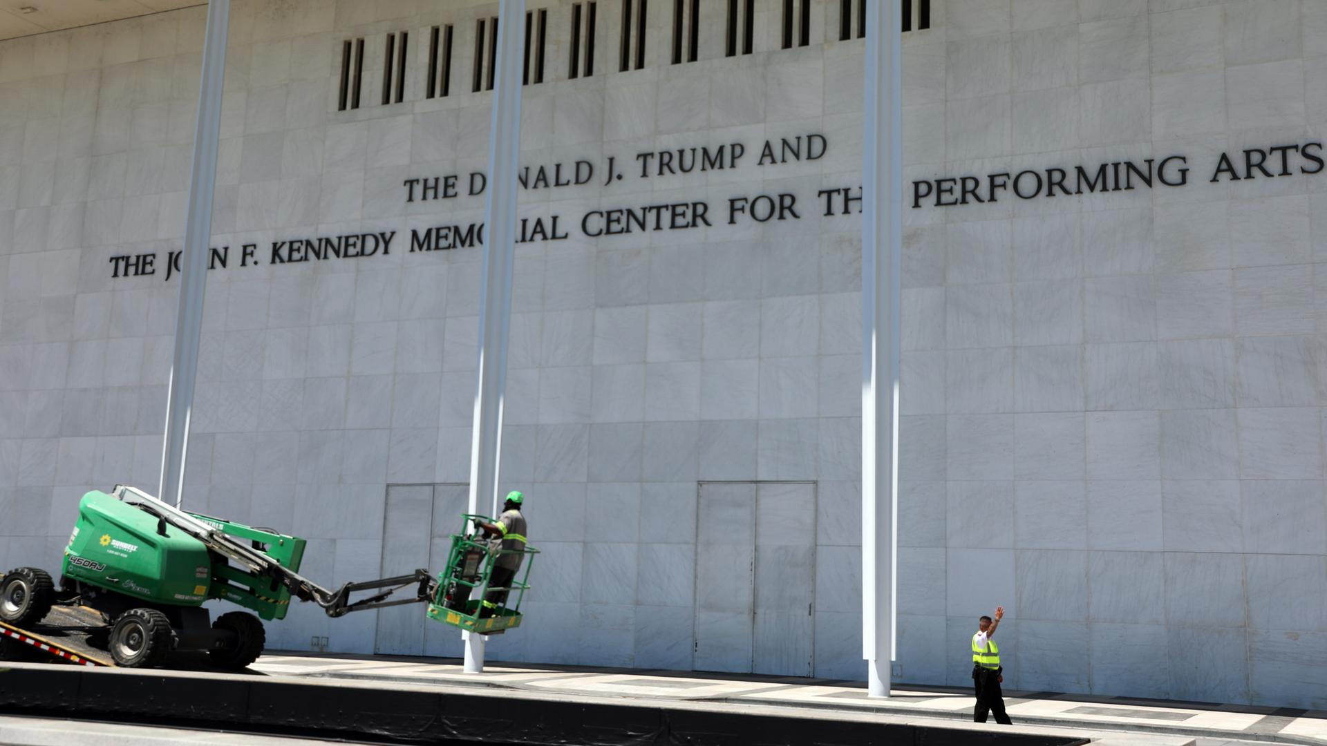 Arbeiter laden vor dem John F. Kennedy Center for the Performing Arts Ausrüstung von einem Tieflader.