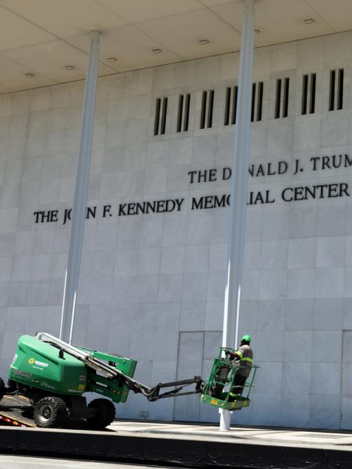 Arbeiter laden vor dem John F. Kennedy Center for the Performing Arts Ausrüstung von einem Tieflader.