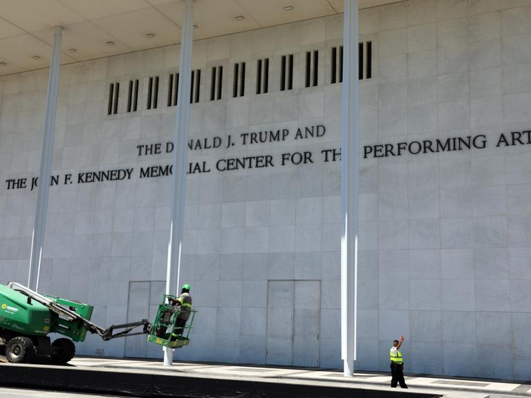 Arbeiter laden vor dem John F. Kennedy Center for the Performing Arts Ausrüstung von einem Tieflader.