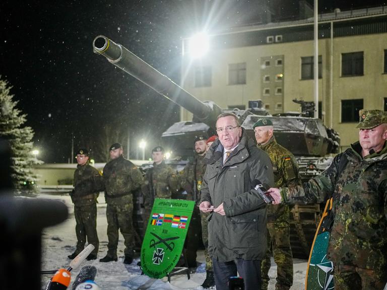 Boris Pistorius (SPD), Bundesminister der Verteidigung, spricht neben Bundeswehrsoldaten des deutschen Einsatzkontingents Enhanced Forward Presence in Rukla bei dem Besuch des NATO-Partners Litauen an einem Leopard 2- Panzer zu den Journalisten.
