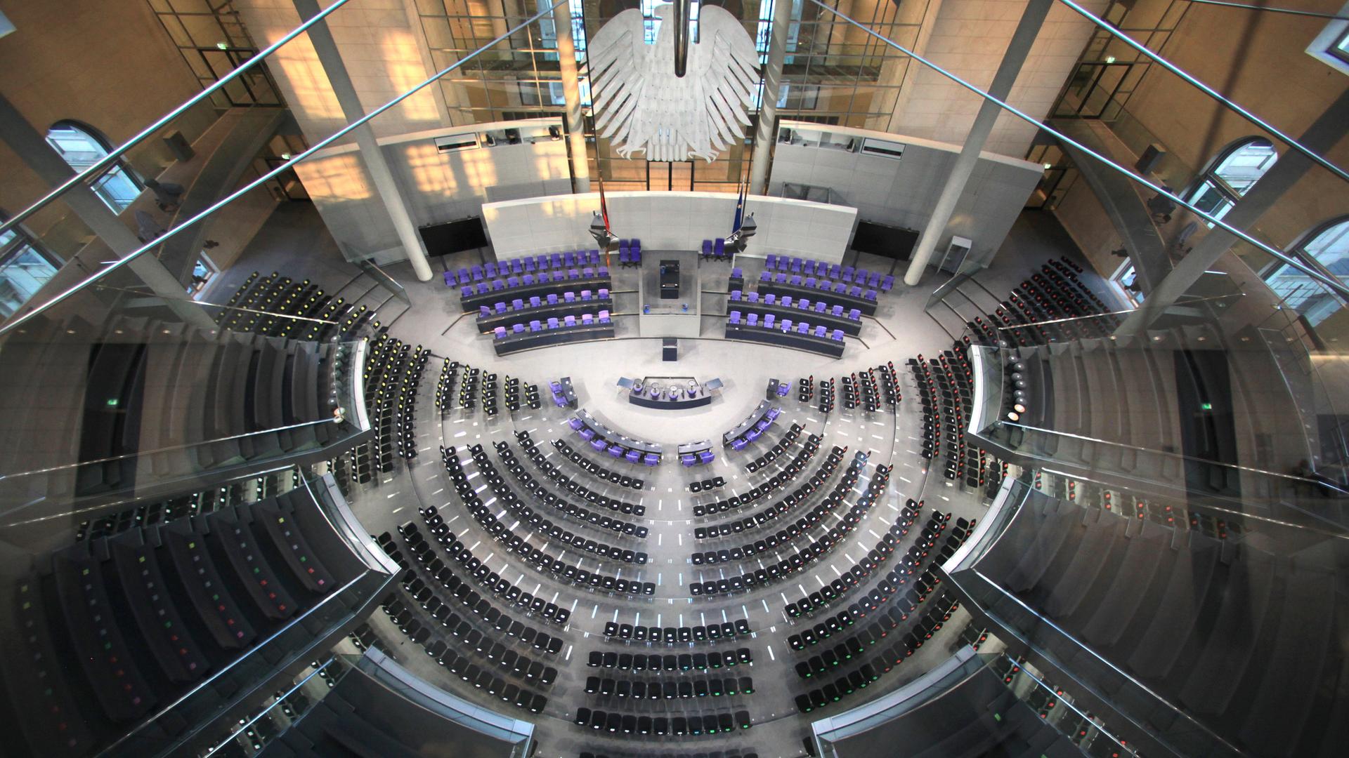 Der Plenarsaal des Deutschen Bundestages, aufgenommen in Berlin im März 2012. Die Sitze der Parlamentarier sind leer, vorn im Saal ist der Bundesadler zu erkennen.