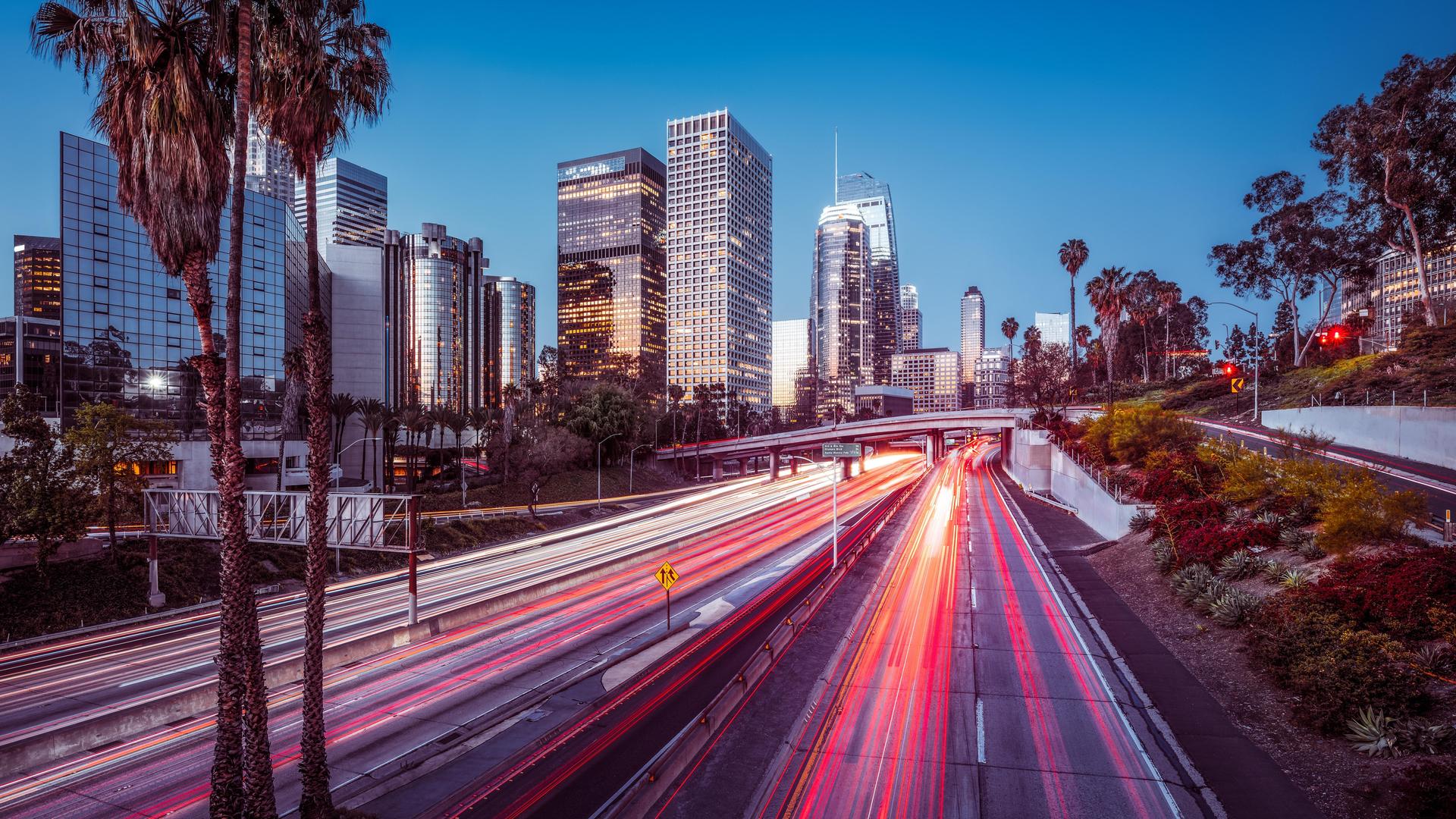 Die Skyline von Los Angeles bei Nacht mit bunt leuchtendem Highway und Wolkenkratzern. Die Skyline von Los Angeles bei Nacht mit bunt leuchtendem Highway und Wolkenkratzern.