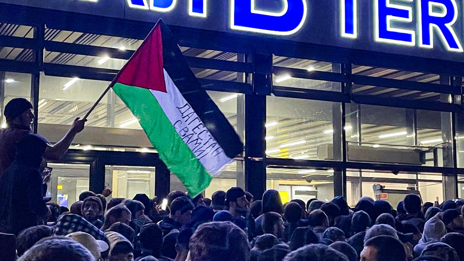 An einem Flughafen in der russischen Teilrepublik Dagestan kam es am 29.10.2023 nach der Landung eines Flugzeugs aus Tel Aviv zu judenfeindlichen Krawallen. Auf der Palästina-Flagge im Bild steht "Dagestan ist mit Euch". An einem Flughafen in der russischen Teilrepublik Dagestan kam es am 29.10.2023 nach der Landung eines Flugzeugs aus Tel Aviv zu judenfeindlichen Krawallen. Auf der Palästina-Flagge im Bild steht "Dagestan ist mit Euch".