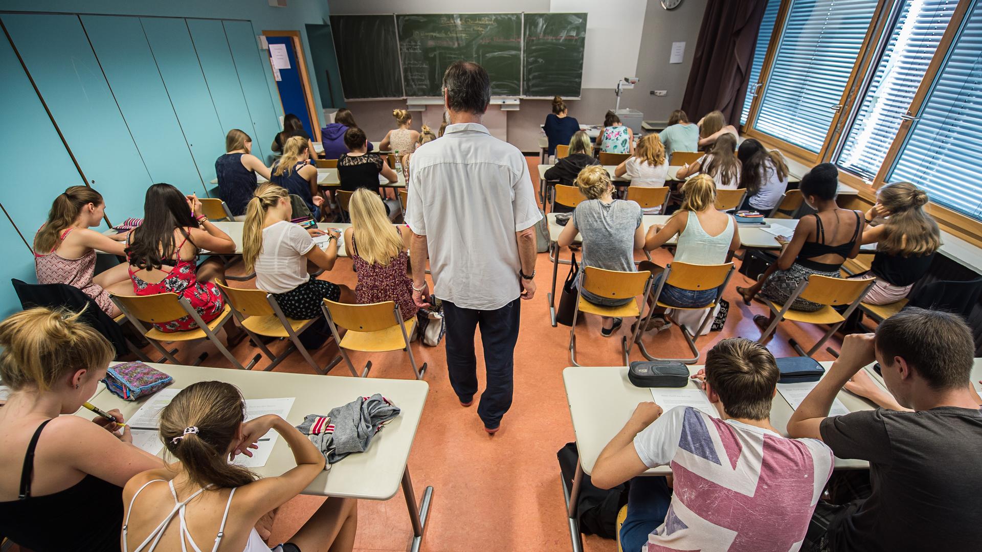 Schüler einer zehnten Klasse eines Gymnasiums sitzen im Unterricht. Schüler einer zehnten Klasse eines Gymnasiums sitzen im Unterricht.