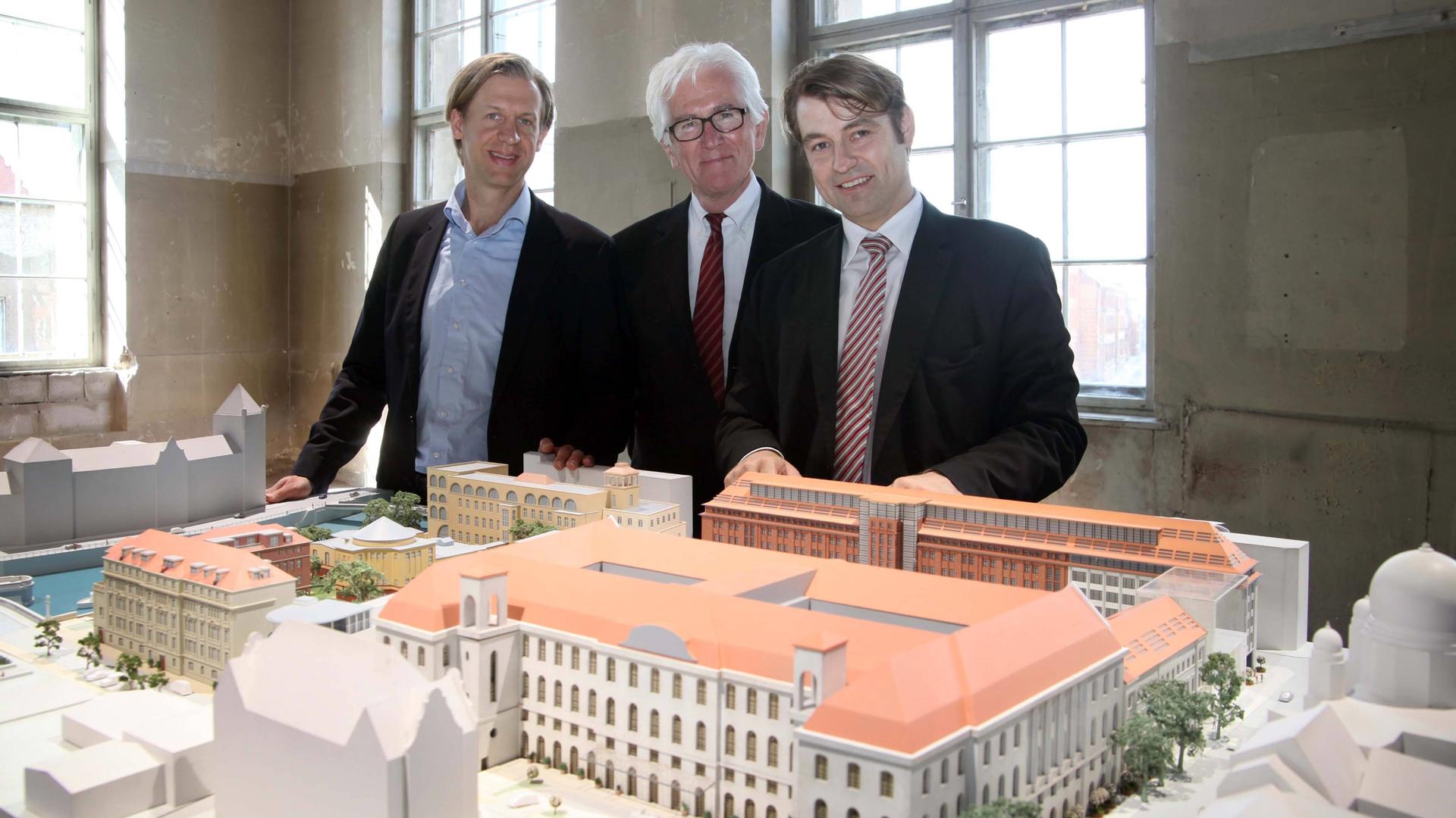 Die Architekten Jonas Olfe und Rüdiger Patzschke und Projektleiter Tobias Enders vor dem Modell des Komplexes . Gesellschaft Architektur Stadtentwicklung Berlin im Jahr 2011.