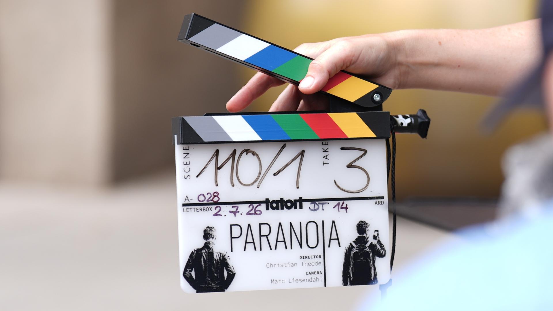 Eine Mitarbeiterin hält eine Filmklappe vor einer Kamera am Set des neuen NDR-Tatort "Paranoia" vor dem Hotel Fraser Suites. Der Krimi soll voraussichtlich in der zweiten Jahreshälfte 2027 in der ARD ausgestrahlt werden. Eine Mitarbeiterin hält eine Filmklappe vor einer Kamera am Set des neuen NDR-Tatort "Paranoia" vor dem Hotel Fraser Suites. Der Krimi soll voraussichtlich in der zweiten Jahreshälfte 2027 in der ARD ausgestrahlt werden.