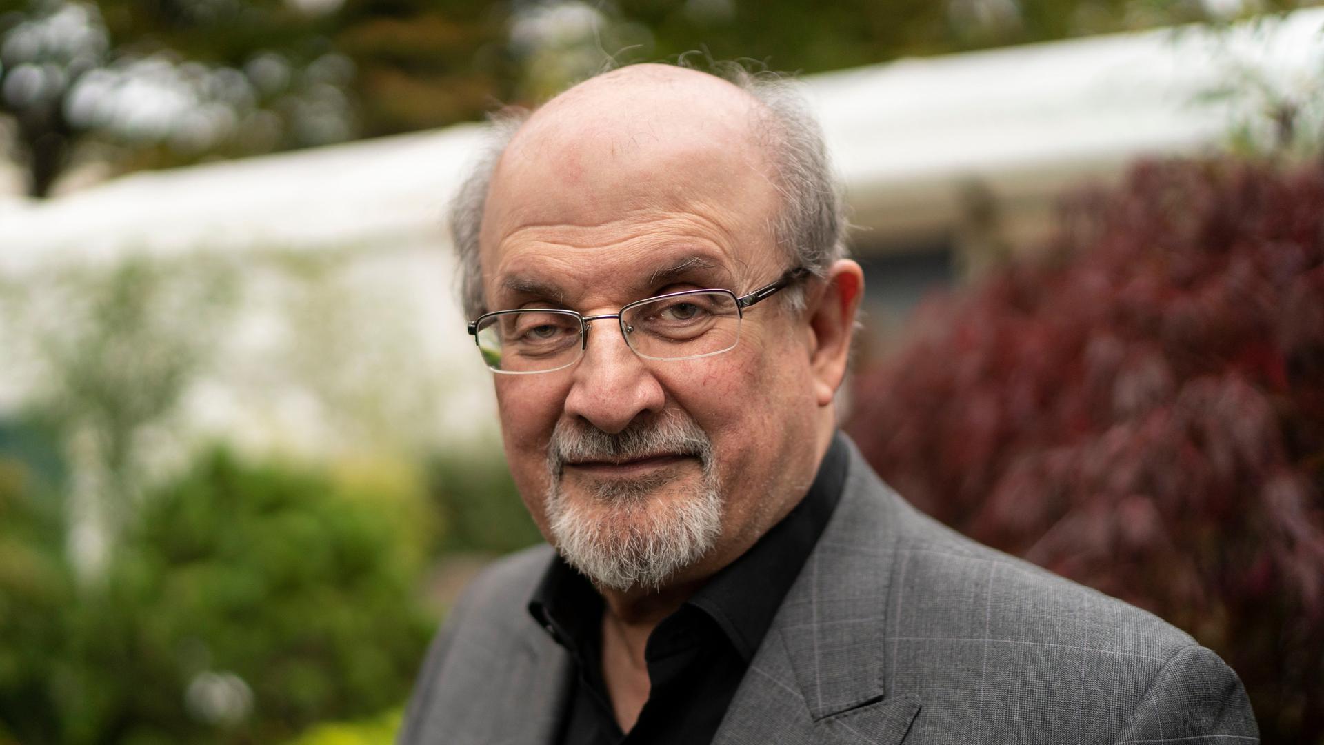 Porträt von Salman Rushdie lächelt in die Kamera.