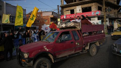 Libanon, Zefta: Nach dem Inkrafttreten eines Waffenstillstands fahren vertriebene Bewohner in Zefta im Südlibanon zurück in ihre Dörfer, während die Einwohner Hisbollah-Fahnen schwenken.