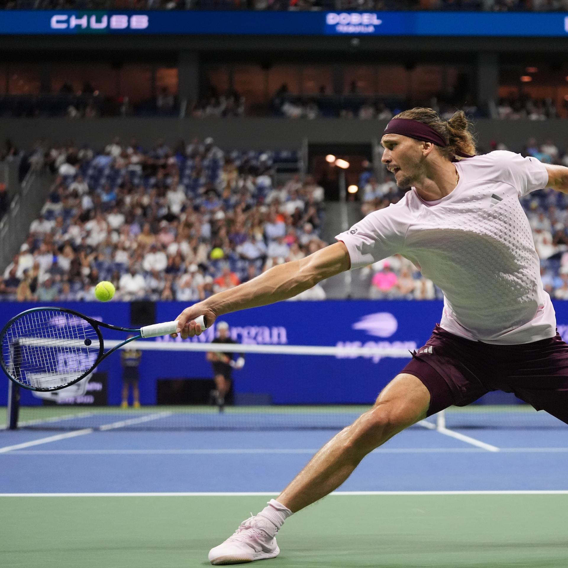 Alexander Zverev macht einen großen Ausfallschritt, um den Tennisball mit dem Schläger zu erreichen. 