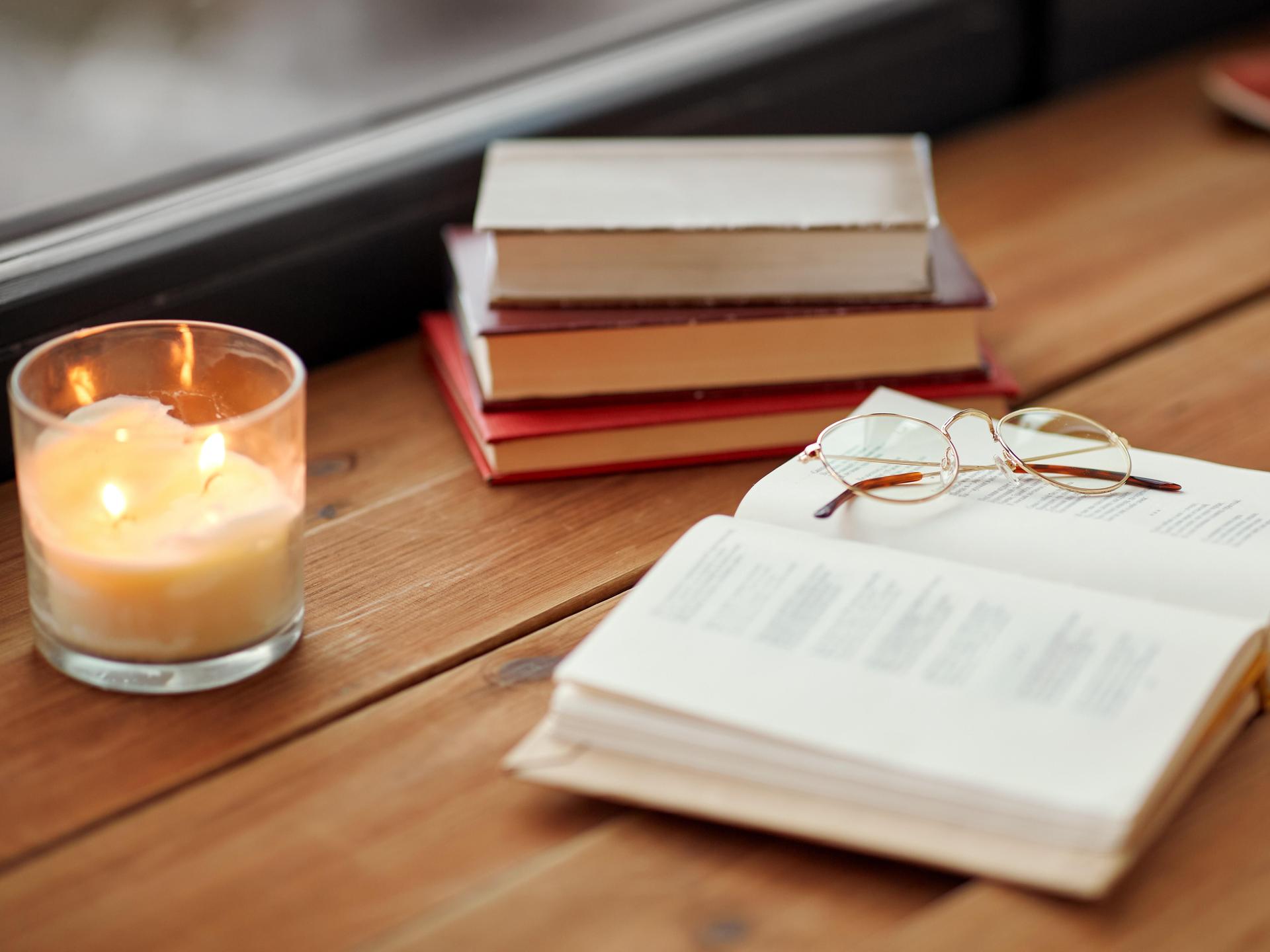 Bücher liegen auf einem Holztisch in einem Raum. 