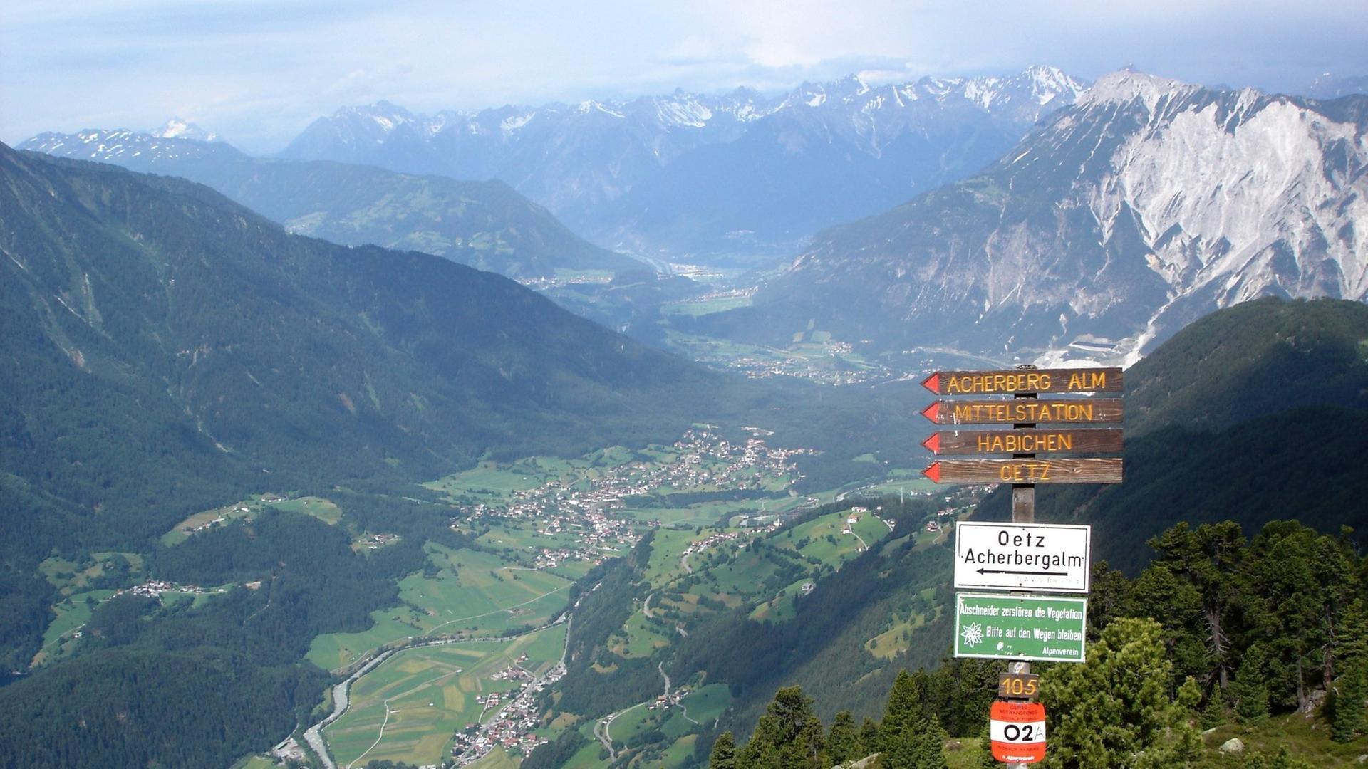 Wegweiser im Gebiet Hoch-Ötz (Tirol) mit Blick afu das Ötztal und das Hochgebirge Wegweiser im Gebiet Hoch-Ötz (Tirol) mit Blick afu das Ötztal und das Hochgebirge