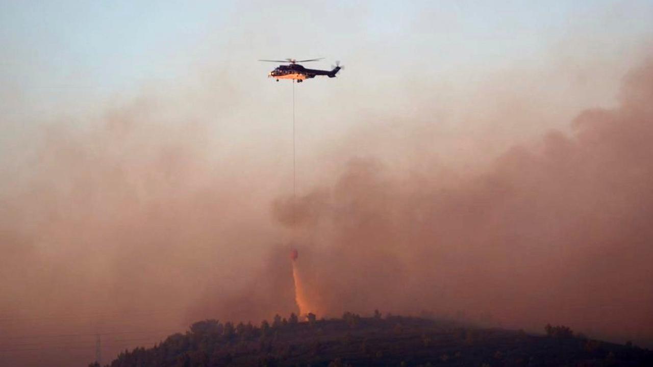 Martigues: Das Handout der Feuerwehr zeigt, wie ein Hubschrauber Flüssigkeit zur Löschung eines Flächenbrands im Süden Frankreichs abwirft.