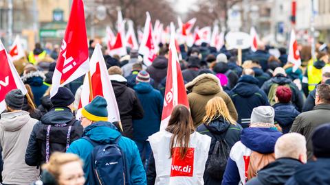 Zahlreiche Mitarbeiter der hannoverschen Verkehrsbetriebe Üstra mit Fahnen und Warnwesten nehmen an einer Verdi-Demonstration teil.