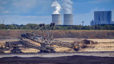 Einer der weltweit größten Schaufelradbagger SRs 6300 im Vorschnitt vom Braunkohletagebau Welzow-Süd, dahinter das Kraftwerk Schwarze Pumpe