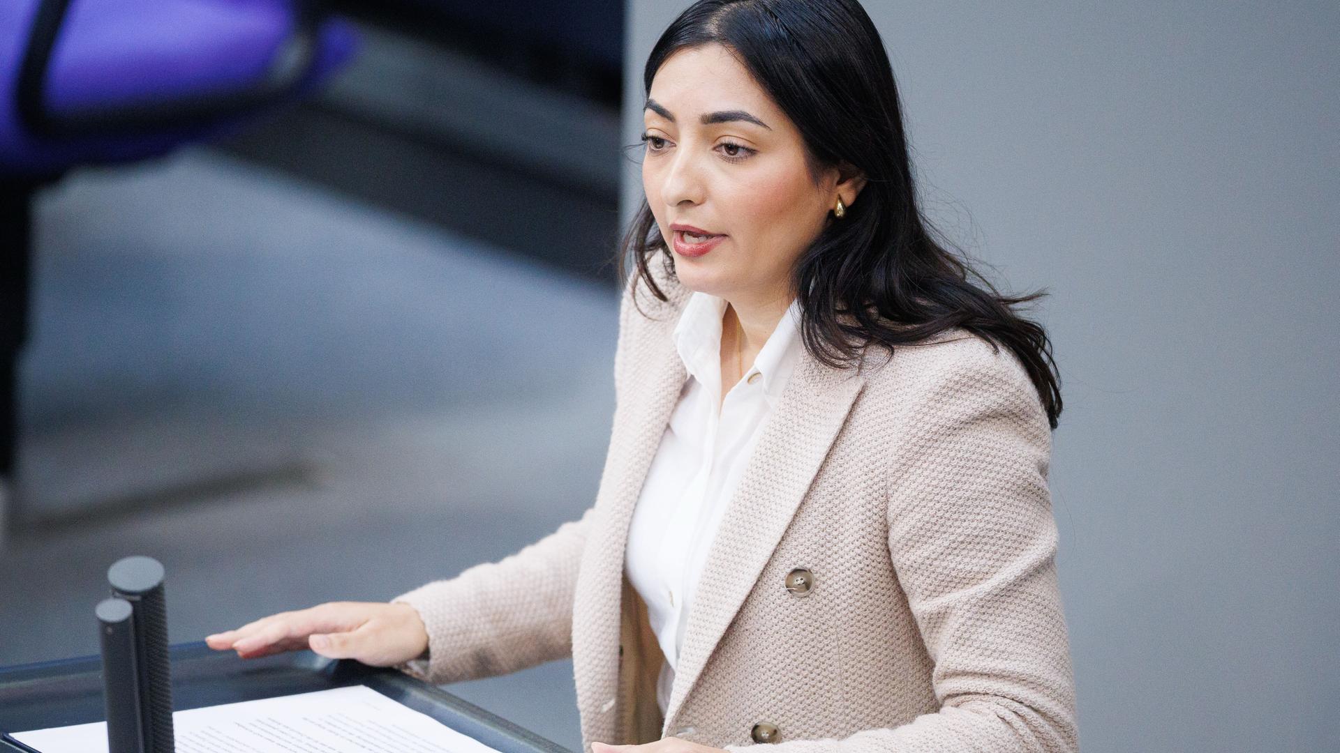 Reem Alabali Radovan, Bundesministerin für wirtschaftliche Zusammenarbeit und Entwicklung von der SPD, steht an einem Rednerpult im Bundestag. sie trägt ein rosafarbenes Jacket und eine weiße Bluse.