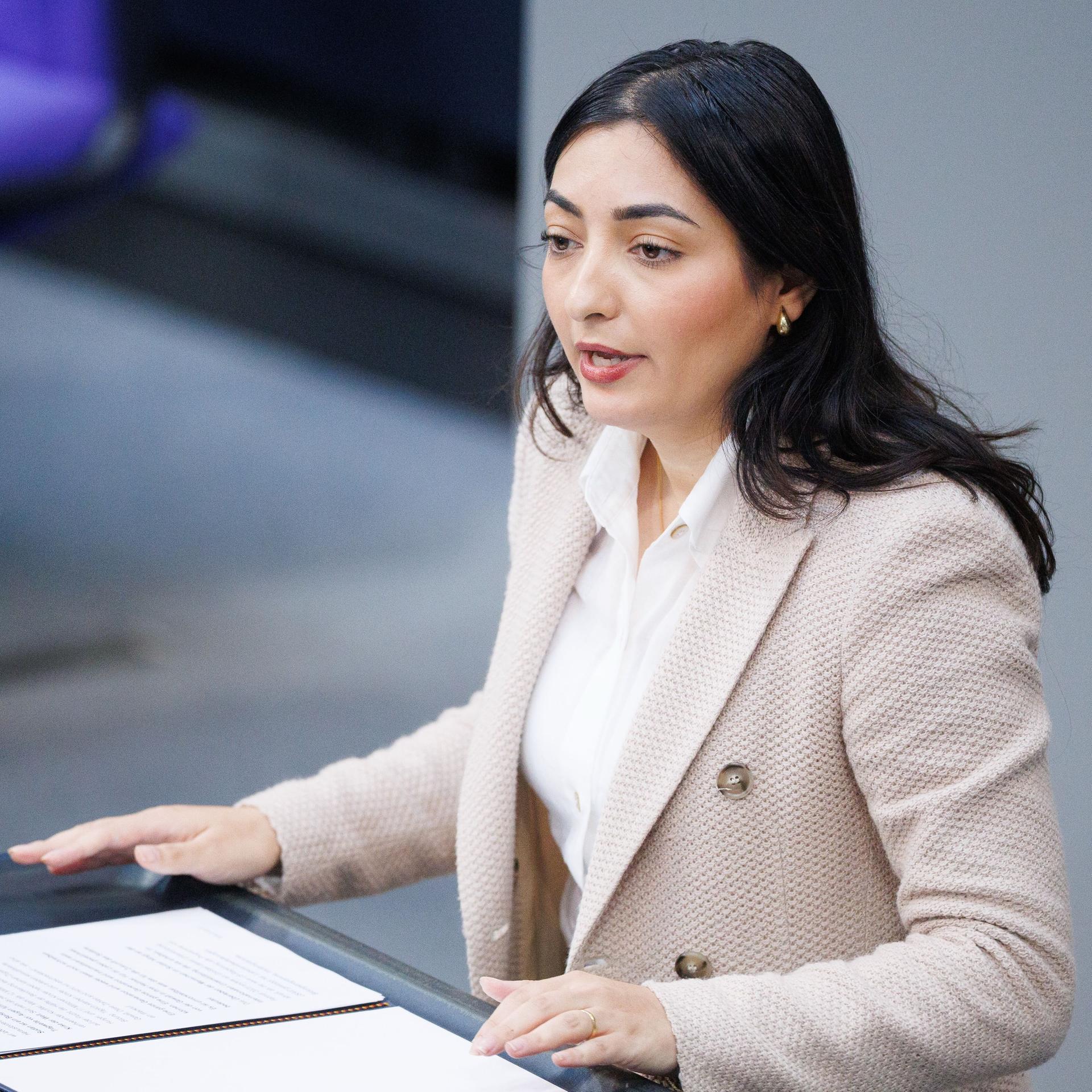 Reem Alabali Radovan, Bundesministerin für wirtschaftliche Zusammenarbeit und Entwicklung von der SPD, steht an einem Rednerpult im Bundestag. sie trägt ein rosafarbenes Jacket und eine weiße Bluse.
