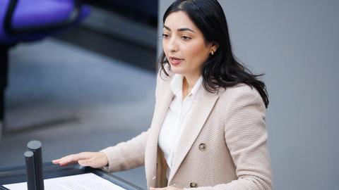 Reem Alabali Radovan, Bundesministerin für wirtschaftliche Zusammenarbeit und Entwicklung von der SPD, steht an einem Rednerpult im Bundestag. sie trägt ein rosafarbenes Jacket und eine weiße Bluse.