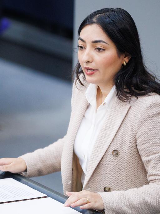 Reem Alabali Radovan, Bundesministerin für wirtschaftliche Zusammenarbeit und Entwicklung von der SPD, steht an einem Rednerpult im Bundestag. sie trägt ein rosafarbenes Jacket und eine weiße Bluse.