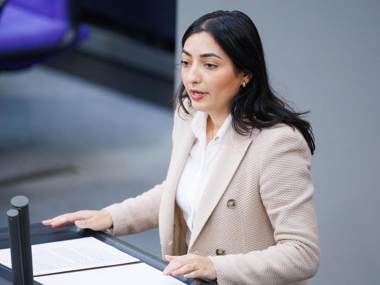 Reem Alabali Radovan, Bundesministerin für wirtschaftliche Zusammenarbeit und Entwicklung von der SPD, steht an einem Rednerpult im Bundestag. sie trägt ein rosafarbenes Jacket und eine weiße Bluse.