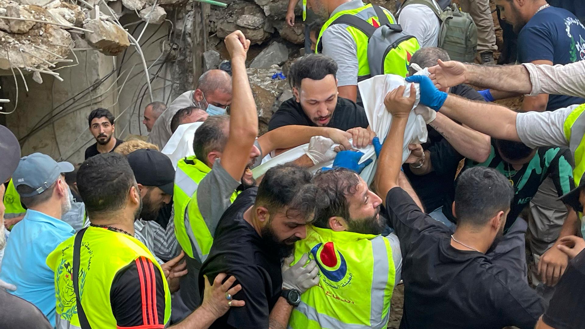 Rettungskräfte in Beirut tragen eine Leiche in einem weißen Tuch. Zuvor hatte die israelische Armee ein Ziel in der libanesischen Hauptstadt angegriffen. 