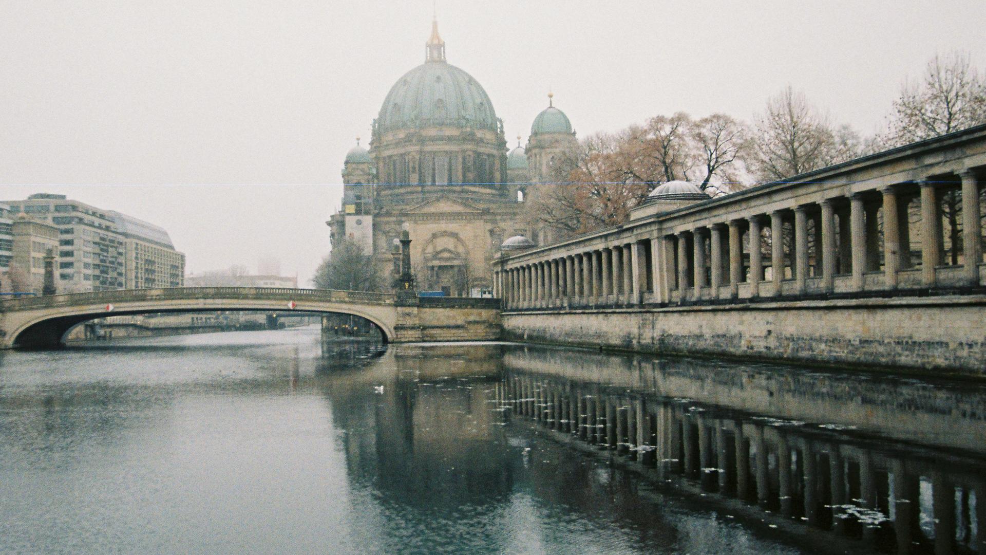 Blick über die Spree zum Dom, der von Nebel umgeben ist.