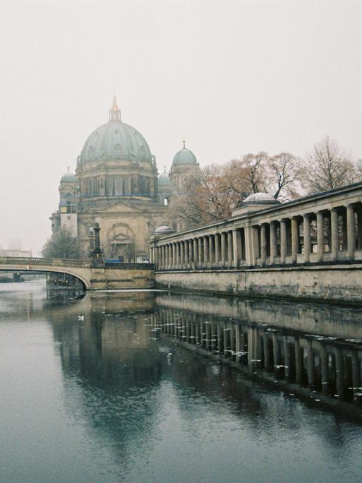 Blick über die Spree zum Dom, der von Nebel umgeben ist.