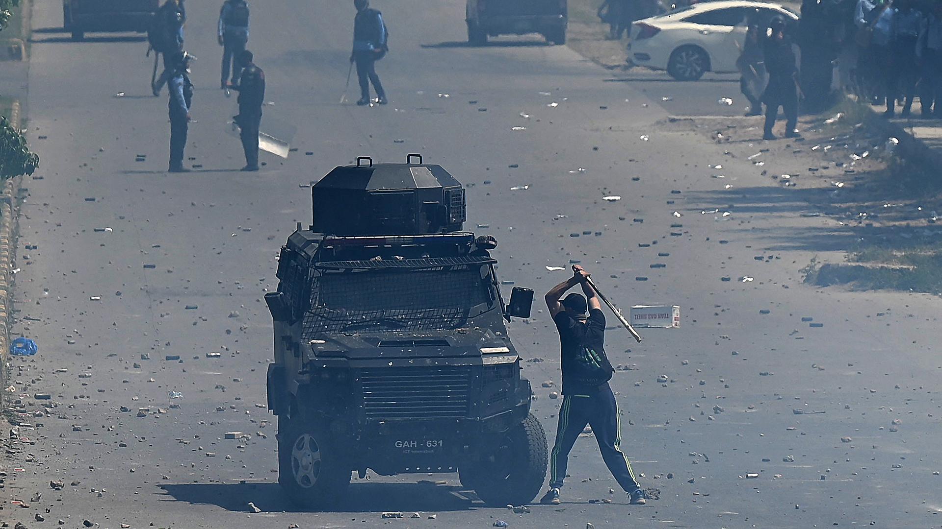 Ein Demonstrant attackiert mit einem Baseballschläger in der Hand ein Armeefahrzeug. Ein Demonstrant attackiert mit einem Baseballschläger in der Hand ein Armeefahrzeug.