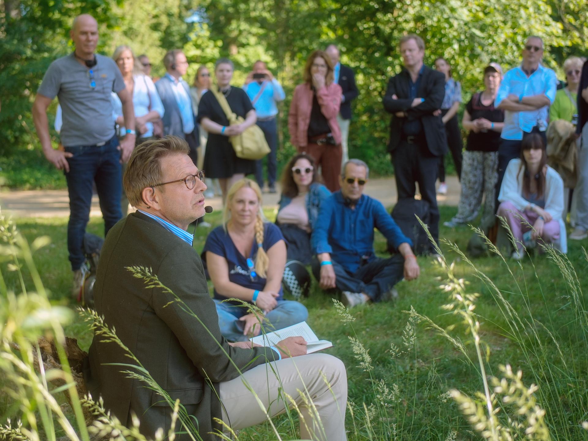 Bestsellerautor Florian Illies liest bei einem Pressetermin aus seinem Buch. Er und seine Gäste sitzen auf einer Wiese auf der Pfaueninsel.