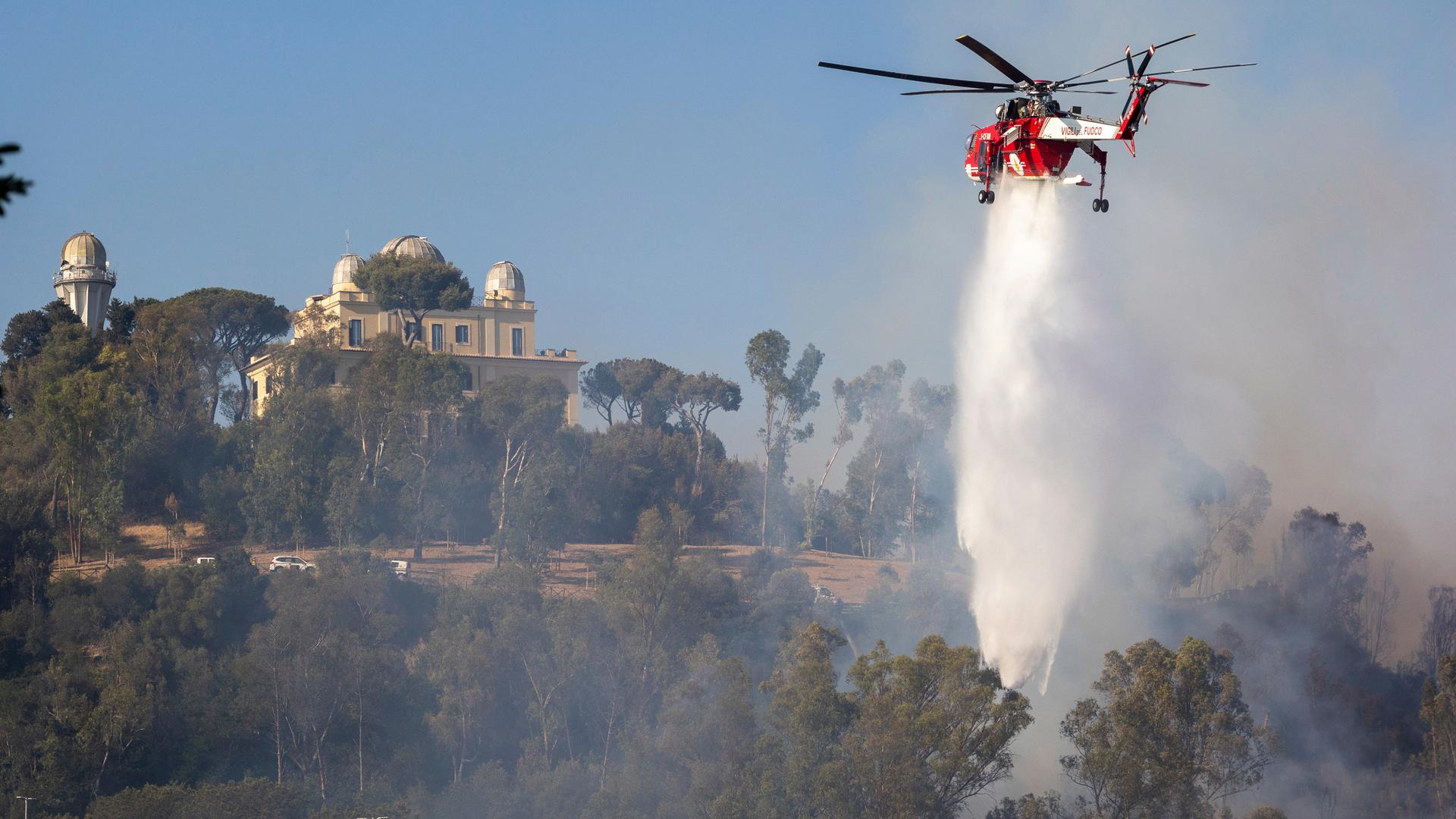 Ein Hubschrauber lässt Wasser auf ein Feuer in Monte Mario in Rom ab.