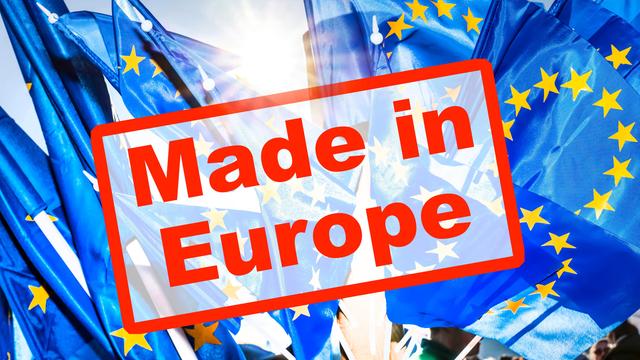 Europafahnen leuchten im Sonnenlicht, davor steht auf einem Schild "Made in Europe"