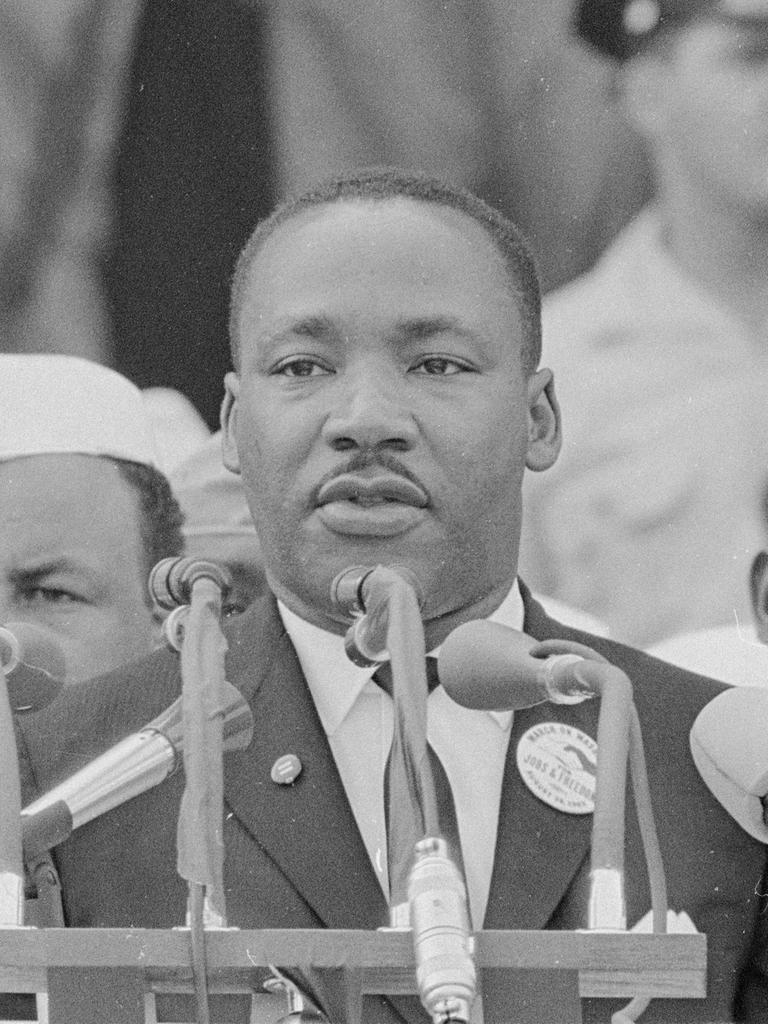Martin Luther King steht auf einer öffentlichen Bühne und hält eine Rede