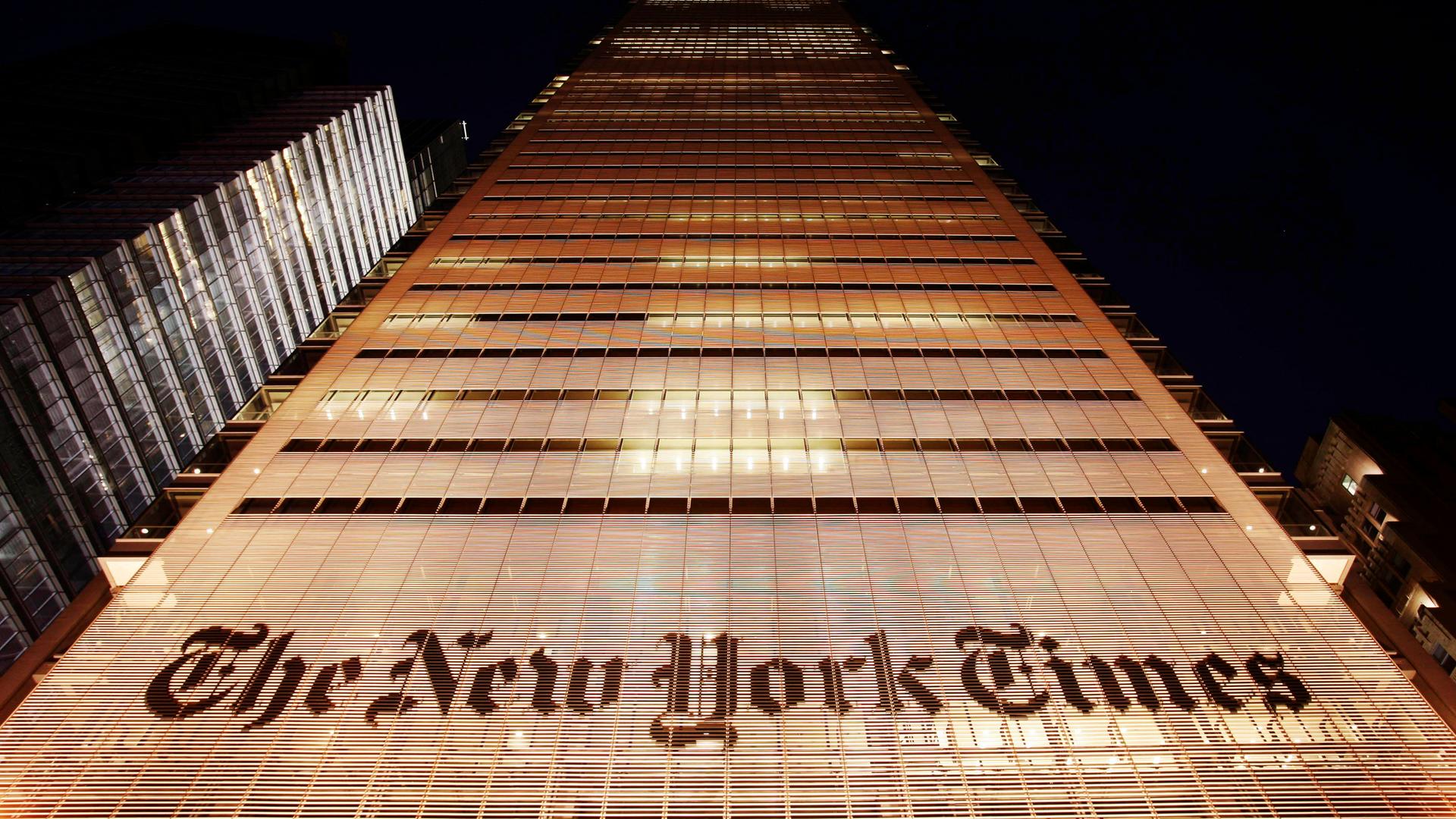 Das "New-York-Times"-Gebäude in der Stadt New York. Es ist erleuchtet, im Hinter-Grund der Nacht-Himmel.