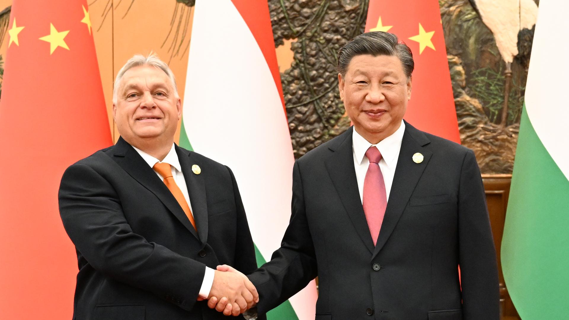 Orban und Xi schütteln sich die Hände. Sie schauen in Richtung der Kamera. Orban und Xi schütteln sich die Hände. Sie schauen in Richtung der Kamera.