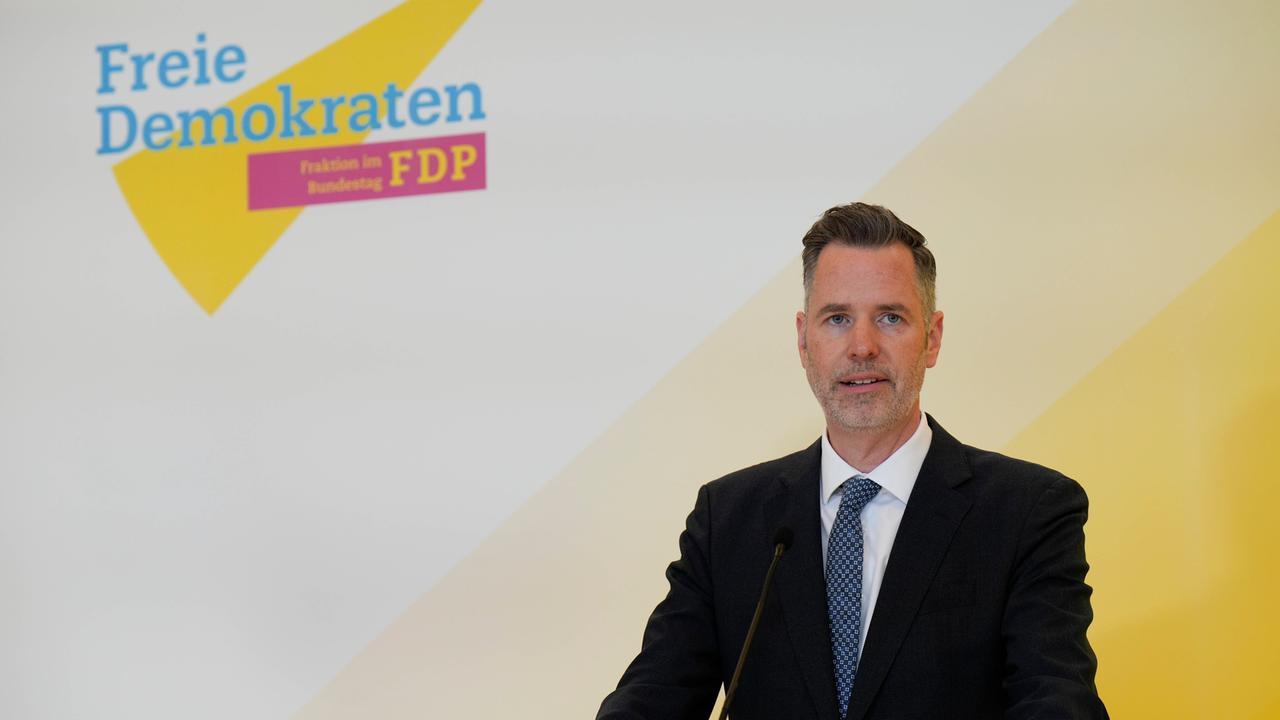 Christian Dürr, Bundesvorsitzender der FPD, gibt ein Statement ab, im Hintergrund das Parteilogo