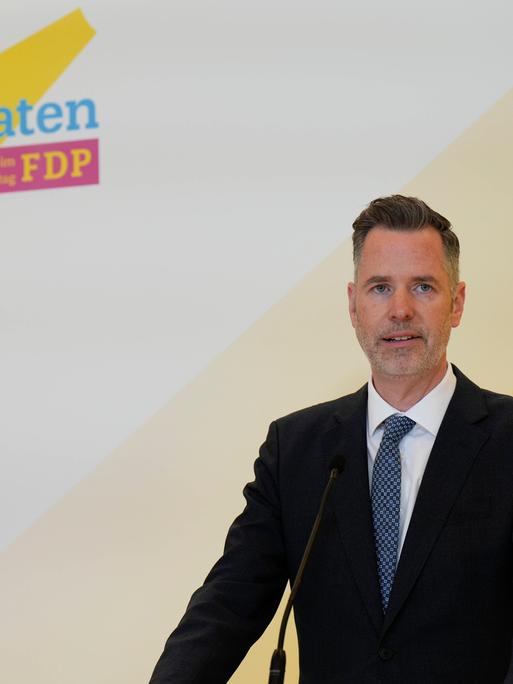 Christian Dürr, Bundesvorsitzender der FPD, gibt ein Statement ab, im Hintergrund das Parteilogo