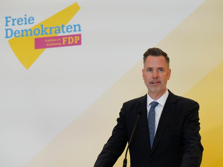 Christian Dürr, Bundesvorsitzender der FPD, gibt ein Statement ab, im Hintergrund das Parteilogo