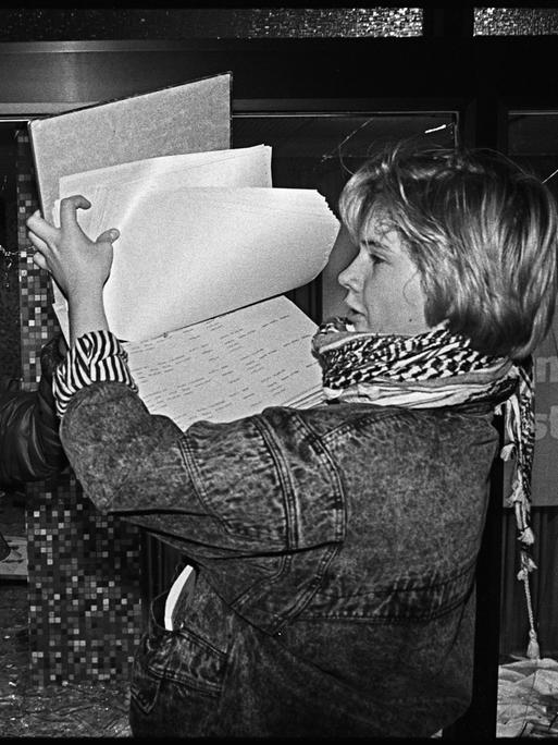 Am Abend des 15. Januar 1990 dringen die Teilnehmer einer Demonstration, auf der die Auflösung des Ministeriums fuer Staatssicherheit der DDR gefordert wird, in den Gebäudekomplex ein. Eine Frau hält Papiere in der Hand. 