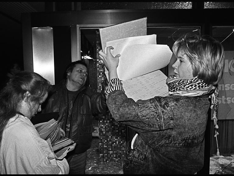 Am Abend des 15. Januar 1990 dringen die Teilnehmer einer Demonstration, auf der die Auflösung des Ministeriums fuer Staatssicherheit der DDR gefordert wird, in den Gebäudekomplex ein. Eine Frau hält Papiere in der Hand. 