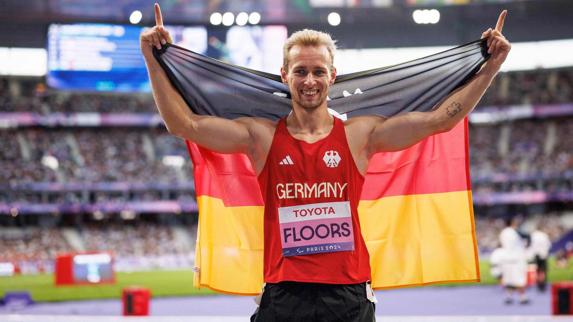 Johannes Floors jubelt mit einer Deutschland-Flagge.